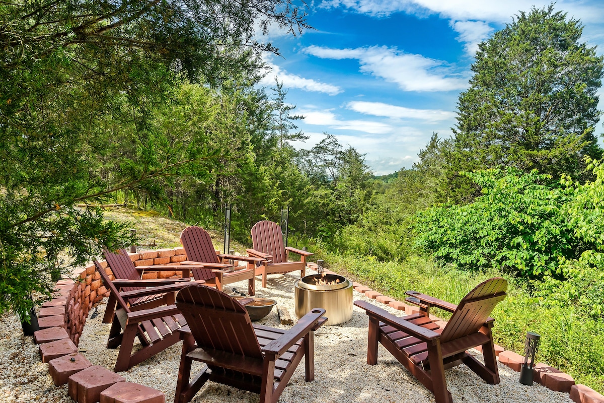 Fire pit with Adirondack chairs in a wooded setting